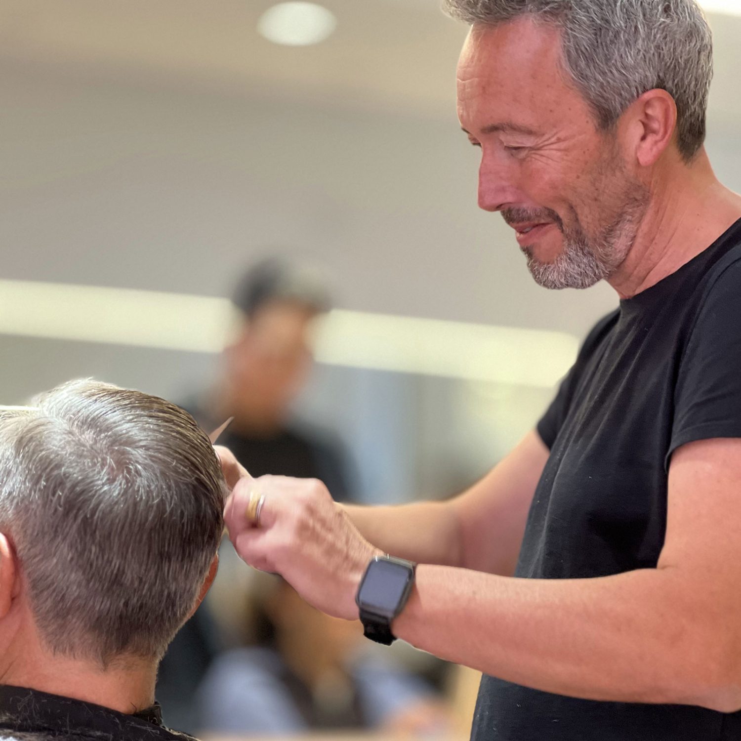 Barbero haciendo un corte de pelo moderno